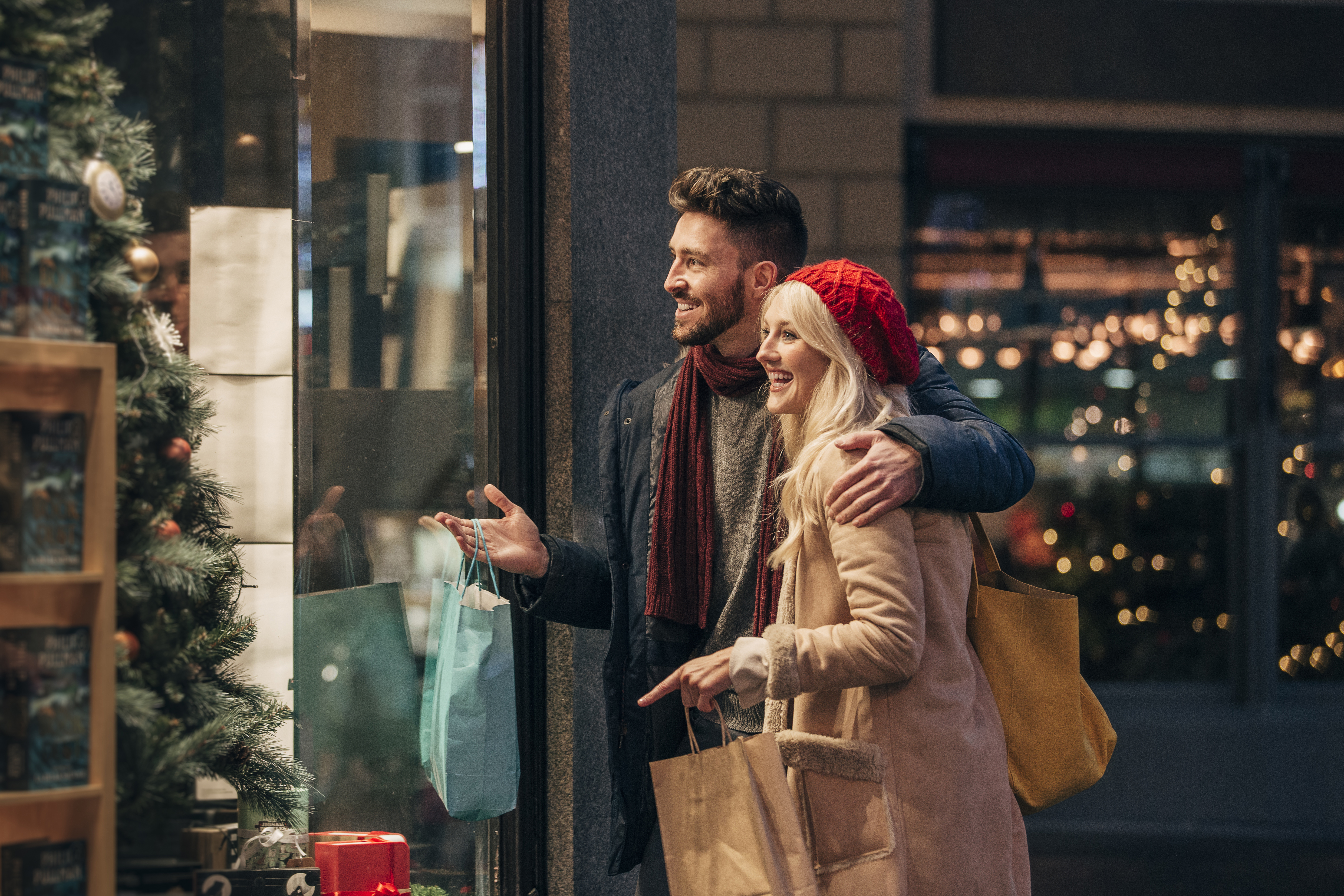 Happy couple window watching during Christmas in New York City.