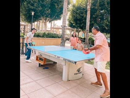 Family enjoying the paddle ball table at Hilton Grand Vacations at MarBrisa in Carlsbad, California. 