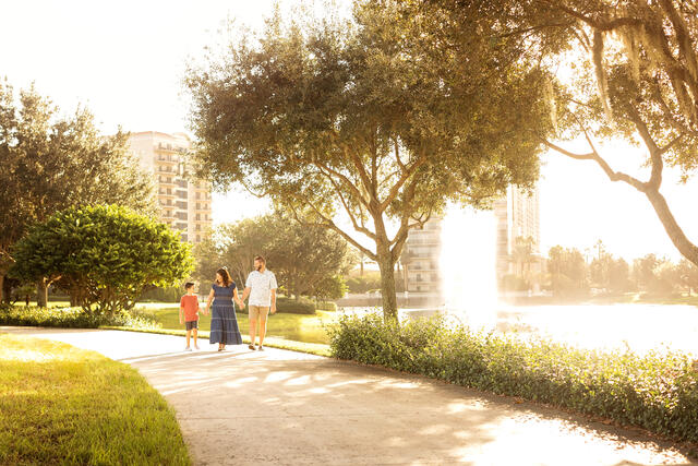 Family walking along a walking path at Parc Soleil® by Hilton Grand Vacations, Orlando, Florida. 
