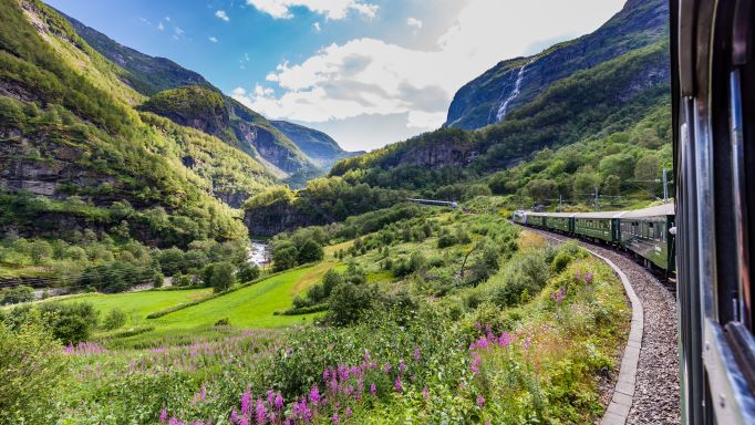 Beautiful mountain vista surrounding train traveling through.