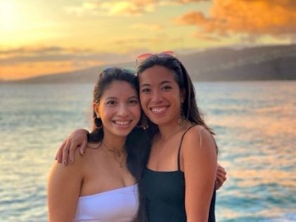 A Hilton Grand Vacations Owner and her friend at the beach at sunset on Oahu, Hawaii