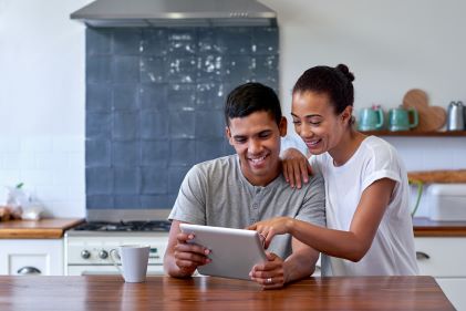 Couple sharing iPad together over coffee.