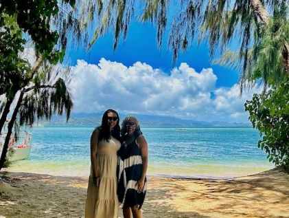 A Hilton Grand Vacations Owner and her daughter-in-law on the beach in Oahu during a tour hosted by HGV Ultimate Access